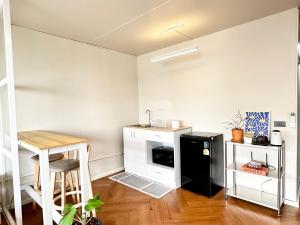 a small kitchen with a black refrigerator and a table at Lykke Room Poppular Condo P1 in Ban Bang Phang