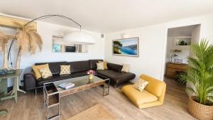 a living room with a couch and a table at Le Repaire de la Cadière à 5mn des plages ! in Saint-Cyr-sur-Mer