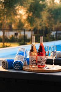 two bottles of wine and two glasses on a table at Karoo Retreat- Self Catering Villas and Guest House in Oudtshoorn