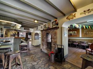 a restaurant with a fireplace and a bar with tables and chairs at ANNORA Bar & Accommodation in Portnoo