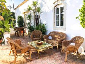 a patio with wicker chairs and a table at Elegant villa with sea view in Loulé + private pool in Loulé