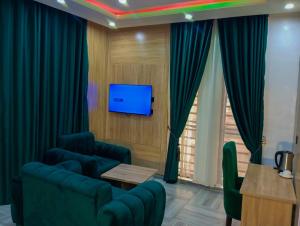 a living room with a couch and a tv at Joebrown Palace Hotel & Suite in Akitan