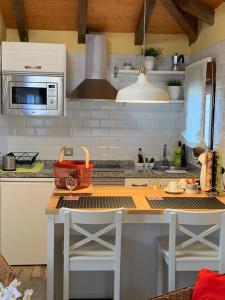 a kitchen with a counter with a table and a microwave at Charming house in Biescas with shared pool in Biescas +56 photos