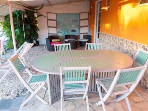 a wooden table and chairs sitting around a table at Appartement charmant à Sainte-Luce avec vue sur la montagne in Sainte-Luce