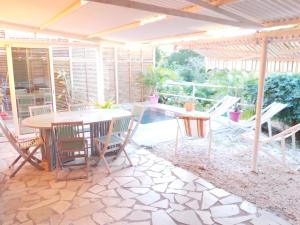a patio with a table and chairs and a pool at Appartement charmant à Sainte-Luce avec vue sur la montagne in Sainte-Luce