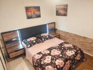a bedroom with a bed with a floral bedspread at Appartement charmant à Sainte-Luce avec vue sur la montagne in Sainte-Luce +16 photos