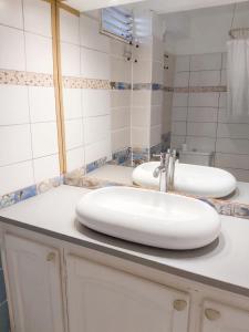 a bathroom with two sinks and a mirror at Appartement charmant à Sainte-Luce avec vue sur la montagne in Sainte-Luce