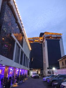 a large building with cars parked in a parking lot at Joebrown Palace Hotel & Suite in Akitan