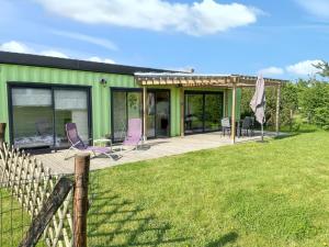 a green house with purple chairs on a deck at Maison cosy à La Bouillie + jardin in La Bouillie