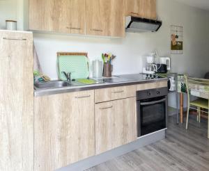 a kitchen with wooden cabinets and a sink at Maison cosy à La Bouillie + jardin in La Bouillie +17 photos