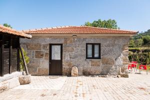 a stone house with a door and a red chair at Idyllic Villa in Fornos + Pool! in Fornos
