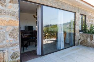 a sliding glass door leading to a patio with a table at Idyllic Villa in Fornos + Pool! in Fornos