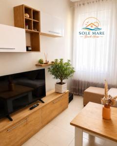 a living room with a large television and a table at Sole Mare - Beach House in Kavajë +2 photos
