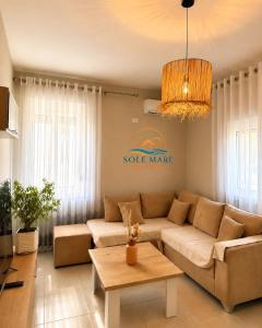 a living room with a couch and a table at Sole Mare - Beach House in Kavajë