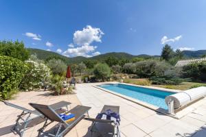 a villa with a swimming pool and two chairs at Soleil de Provence in Nyons