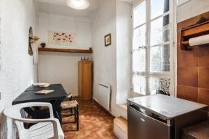 a small kitchen with a table and a window at Appartement cocooning à Barrême, 30 m² avec balcon in Barrême