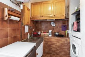 a small kitchen with wooden cabinets and a sink at Appartement cocooning à Barrême, 30 m² avec balcon in Barrême