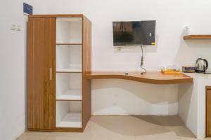 a wooden desk with a computer in a room at Timeless Sevilla Luxe in Ngemplak