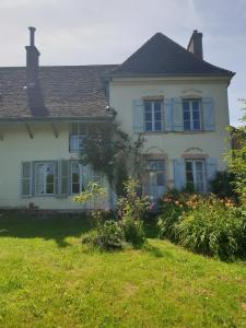 a white house with flowers in the yard at Charming room in Sornay