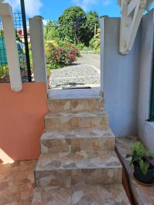 a set of stone steps leading up to a building at Maison charmante à Petit-Bourg avec piscine partagée in Petit-Bourg