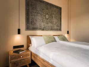 a bedroom with a bed and a painting on the wall at D&C Hotel Sulingen in Sulingen