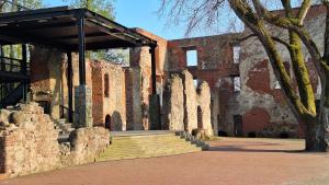 an old brick building with stairs in front of it at Petite Haven in Grobiņa +1 photo