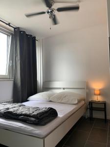 ein Bett in einem Zimmer mit Deckenventilator in der Unterkunft Hostel Cologne in Köln