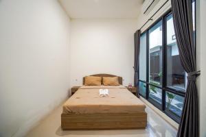 a bedroom with a bed and a large window at Timeless Sevilla Luxe in Ngemplak +29 photos