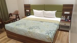 a bedroom with a bed with a green headboard at Vani Hotel Golden Petals in Una
