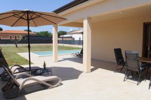 a patio with a table and chairs and an umbrella at Villa GB in Brtonigla