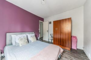 a bedroom with a bed and a purple wall at Maison conviviale à Bourbon-Lancy avec équipements modernes in Bourbon-Lancy +15 photos