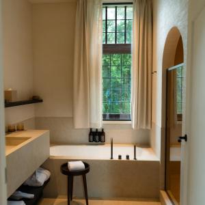 a bathroom with a bath tub under a window at Priorij Corsendonk in Oud-Turnhout +32 photos