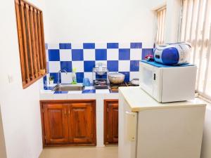 a kitchen with a sink and a microwave at Charming apartment in M'bour + 100 m² + pool in Mbour