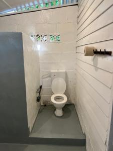 a small bathroom with a toilet in a stall at The Nest in Cherating