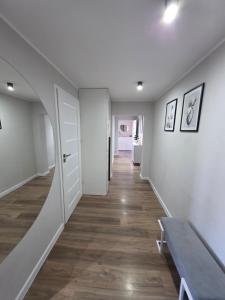 a hallway with white walls and a wooden floor at Majowy in Siedlce