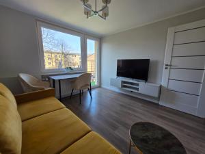 a living room with a couch and a television at Majowy in Siedlce