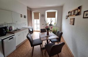 a kitchen with a table and chairs in a kitchen at Ferienwohnung MIWE Gesundheitszent in Forst +4 photos