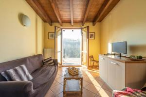 a living room with a couch and a tv at Charming House in Vesime with Shared Pool in Vesime