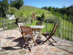 a table and chairs on a patio with a fence at Charming House in Vesime with Shared Pool in Vesime