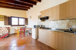 a kitchen with wooden cabinets and a table with chairs at Charming House in Vesime with Shared Pool in Vesime +12 photos