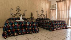 a bedroom with two beds and a table with two swans at CH Paradise Condesa in Acapulco +11 photos
