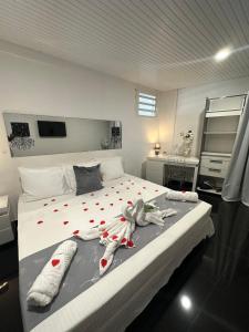 a bedroom with a large bed with towels on it at Appartement charmant à Sainte-Rose, 60m² + piscine in Sainte-Rose