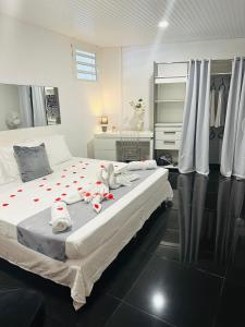 a bedroom with a bed with a stuffed animal on it at Appartement charmant à Sainte-Rose, 60m² + piscine in Sainte-Rose +39 photos