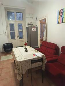 a living room with a table and a red couch at Station Backpackers in Budapest +10 photos