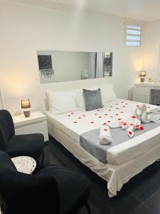 a bedroom with a bed with red hearts on it at Appartement charmant à Sainte-Rose, 60m² + piscine in Sainte-Rose