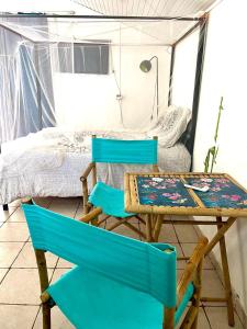 two chairs and a table in a room with a bed at Appartement moderne à Le Lamentin avec piscine partagée - 20m² in Le Lamentin
