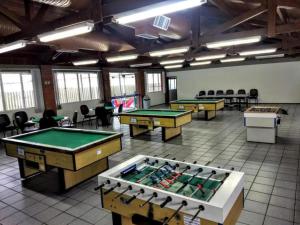 a room with several tables and ping pong balls at FECEP Pousada - 5 minutos a pé da praia in Guaratuba