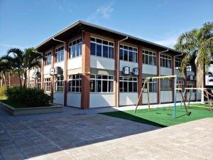 a building with a playground in front of it at FECEP Pousada - 5 minutos a pé da praia in Guaratuba