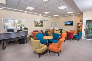 a waiting room with a piano and chairs at Aloney Habashan Guest village in Alonei Habashan