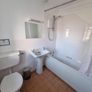 a bathroom with a tub and a sink and a toilet at Oer in Llangian